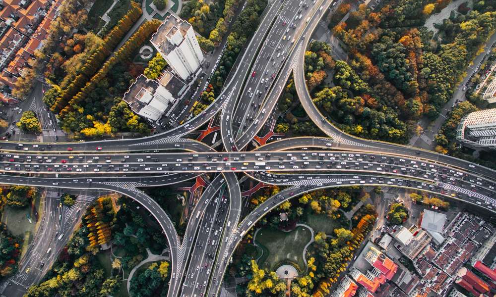 Flygbild över ett motorvägskoppel med vägar fulla av bilar.